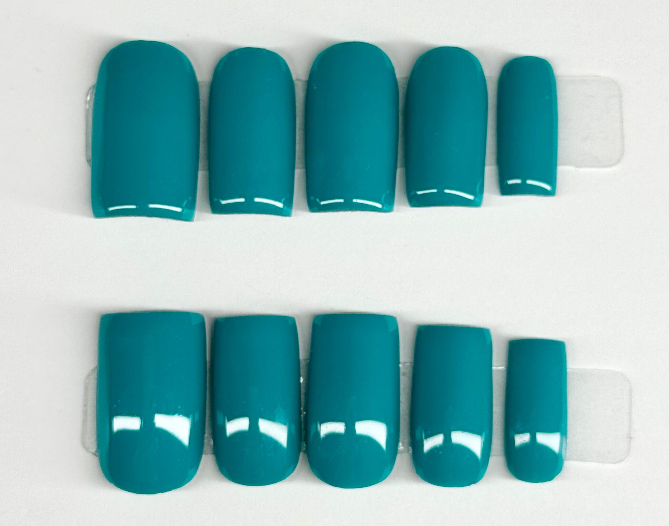 Teal nail polish samples on a white background