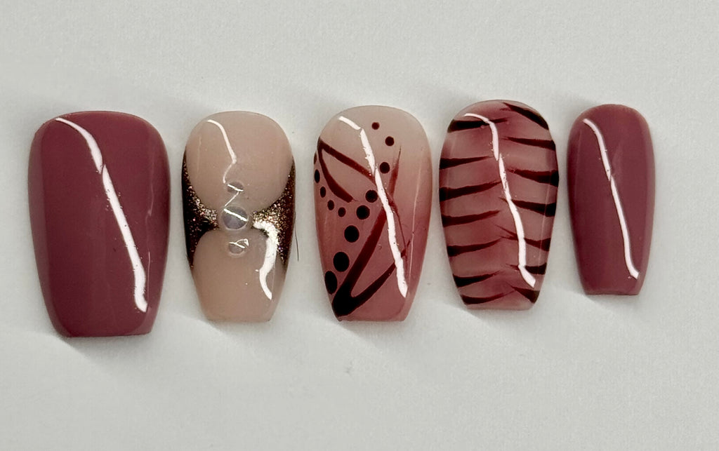 Five nail samples with different designs on a light gray background