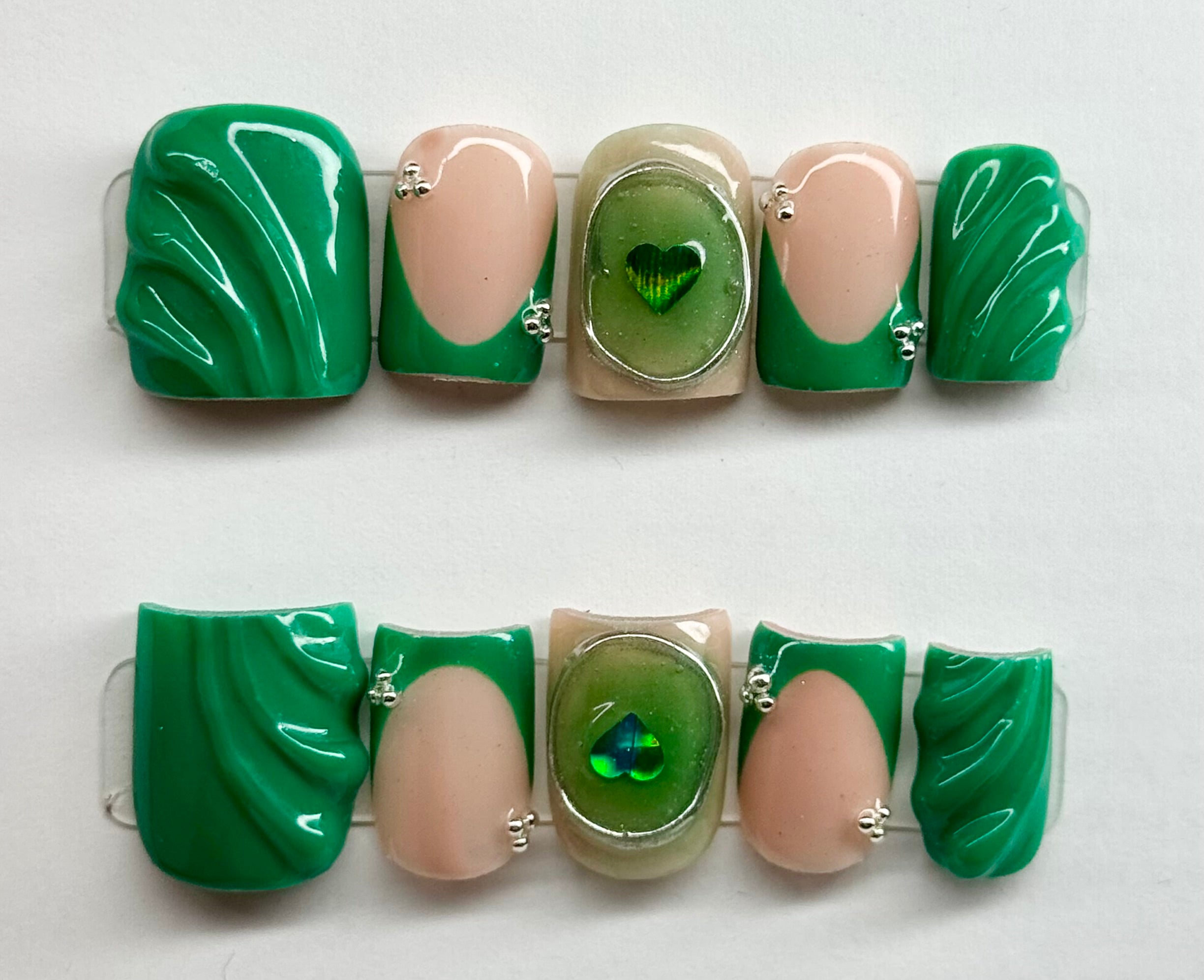 Jewelry set with green and beige stones on a white background