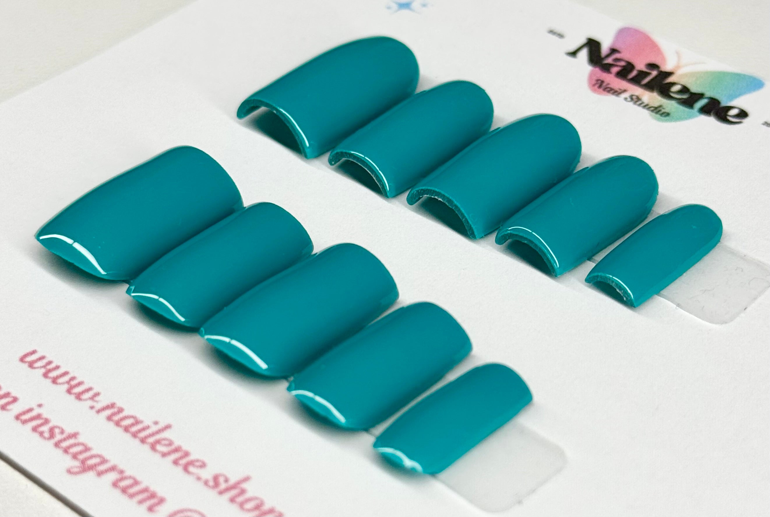 Teal nail extensions on a clear sheet with 'Nailene' branding.