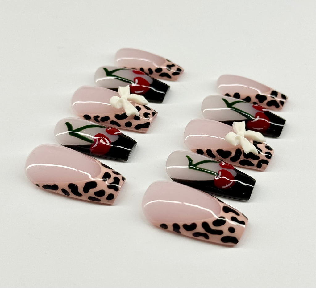 Set of decorative false nails with leopard print and floral designs on a white background
