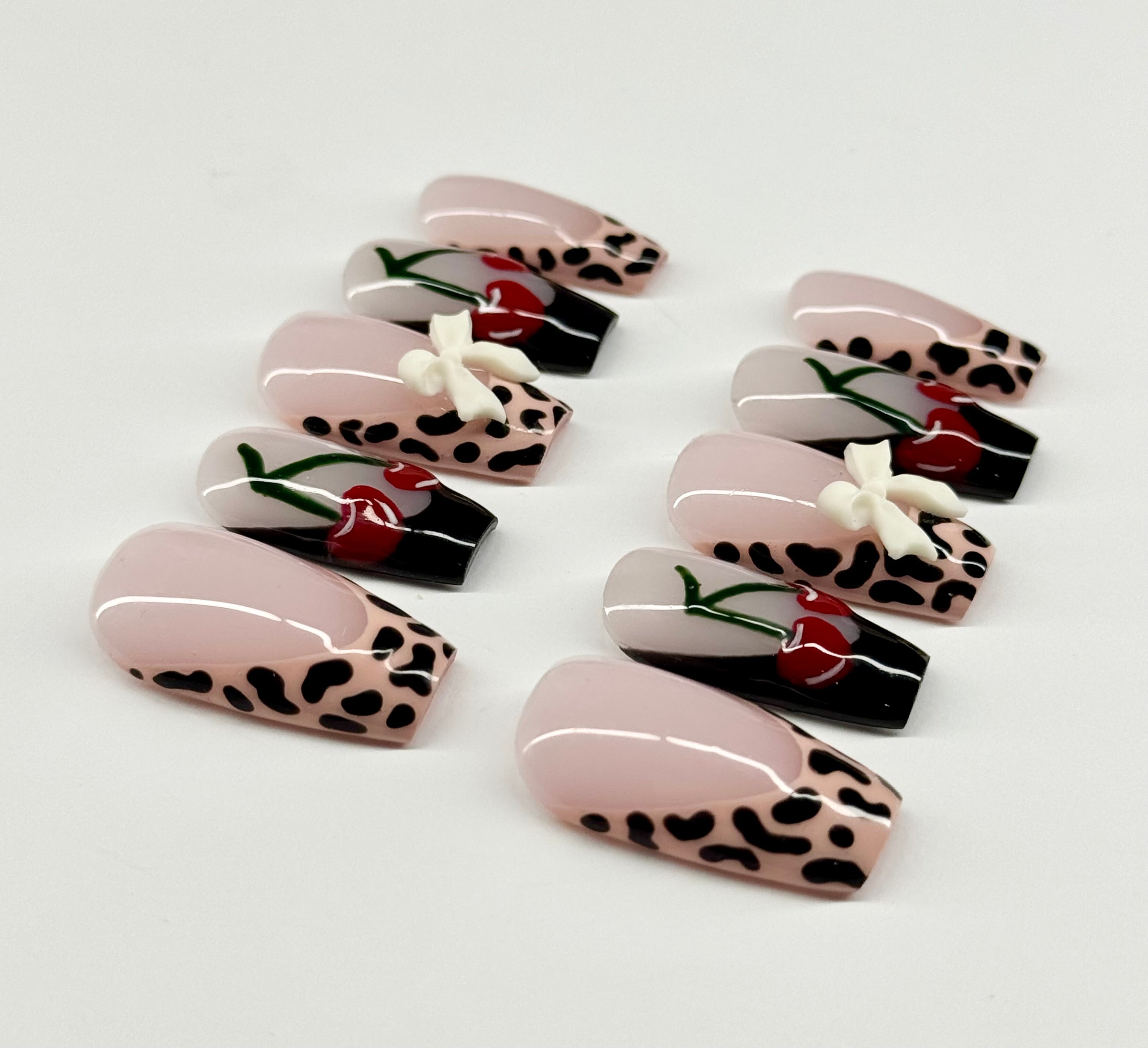 Set of decorative false nails with leopard print and floral designs on a white background