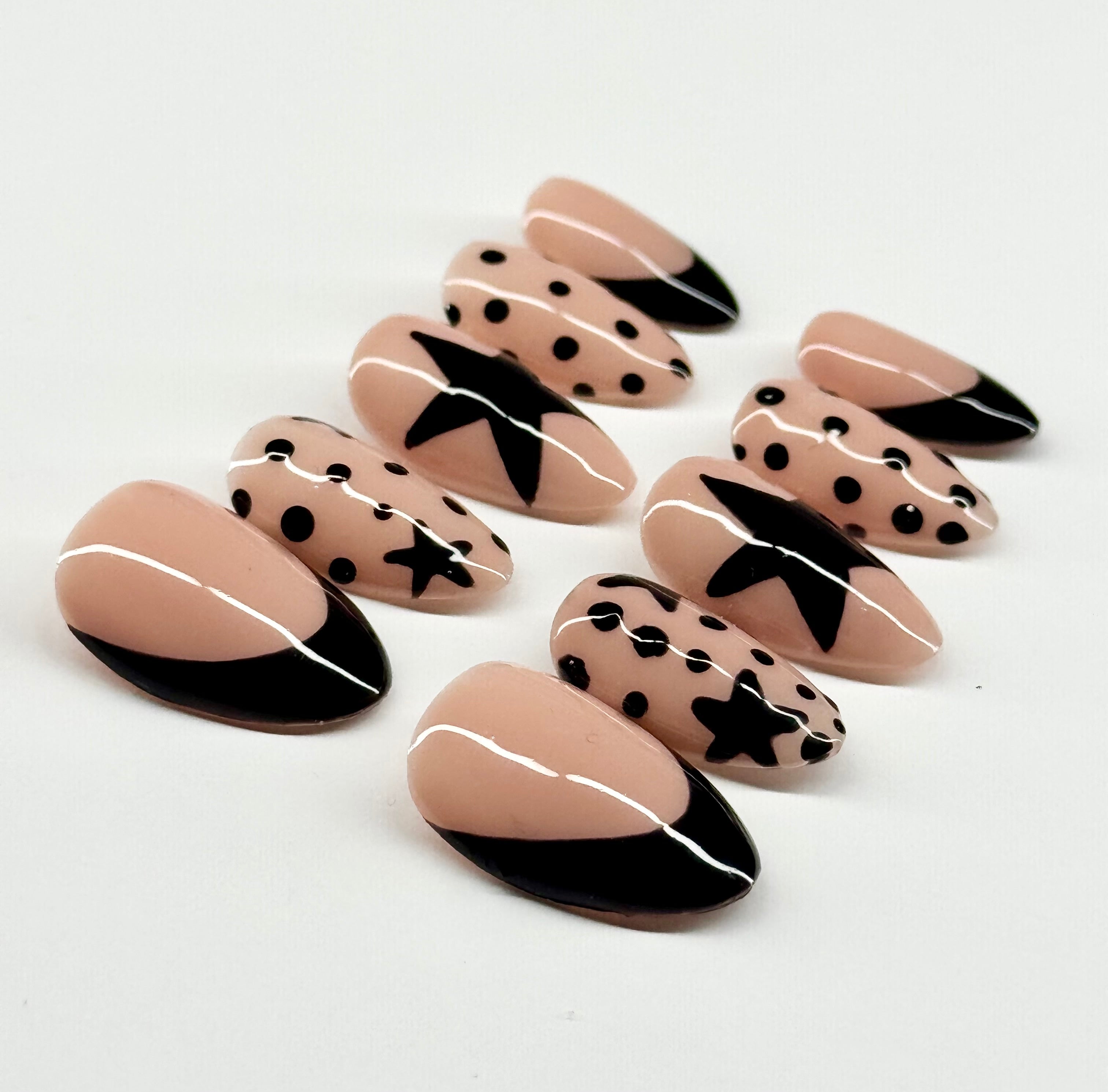 Set of nail art designs with black and white patterns on a light background