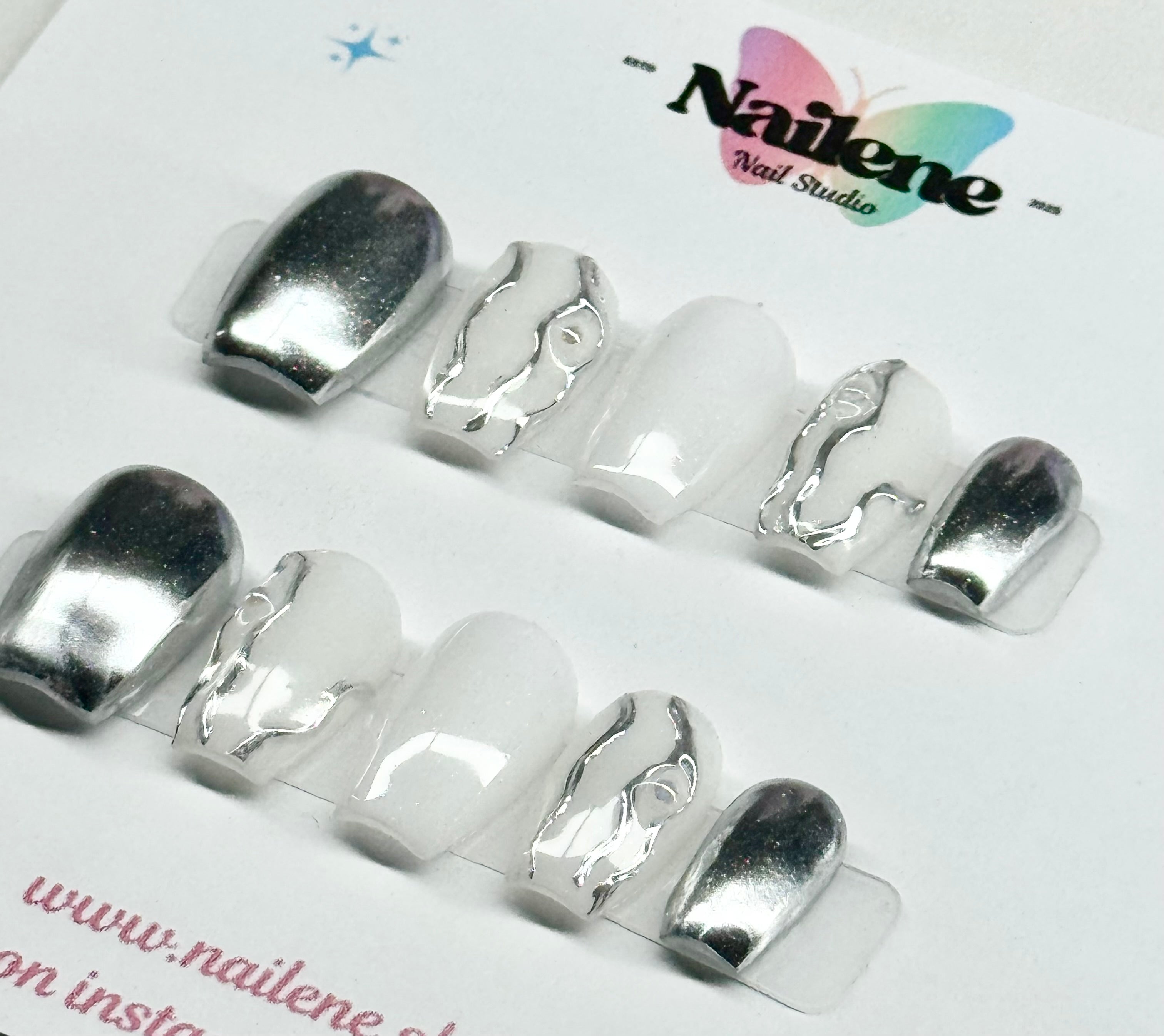 Silver nail tips on a clear plastic sheet with 'Nailene' branding.